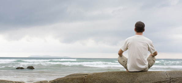 Man on edge of beach contemplating